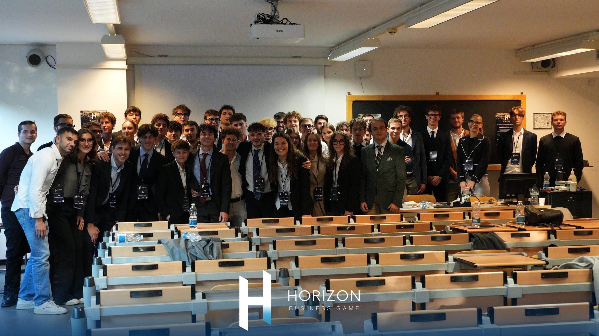 Foto di gruppo di studenti in abito formale in un'aula universitaria